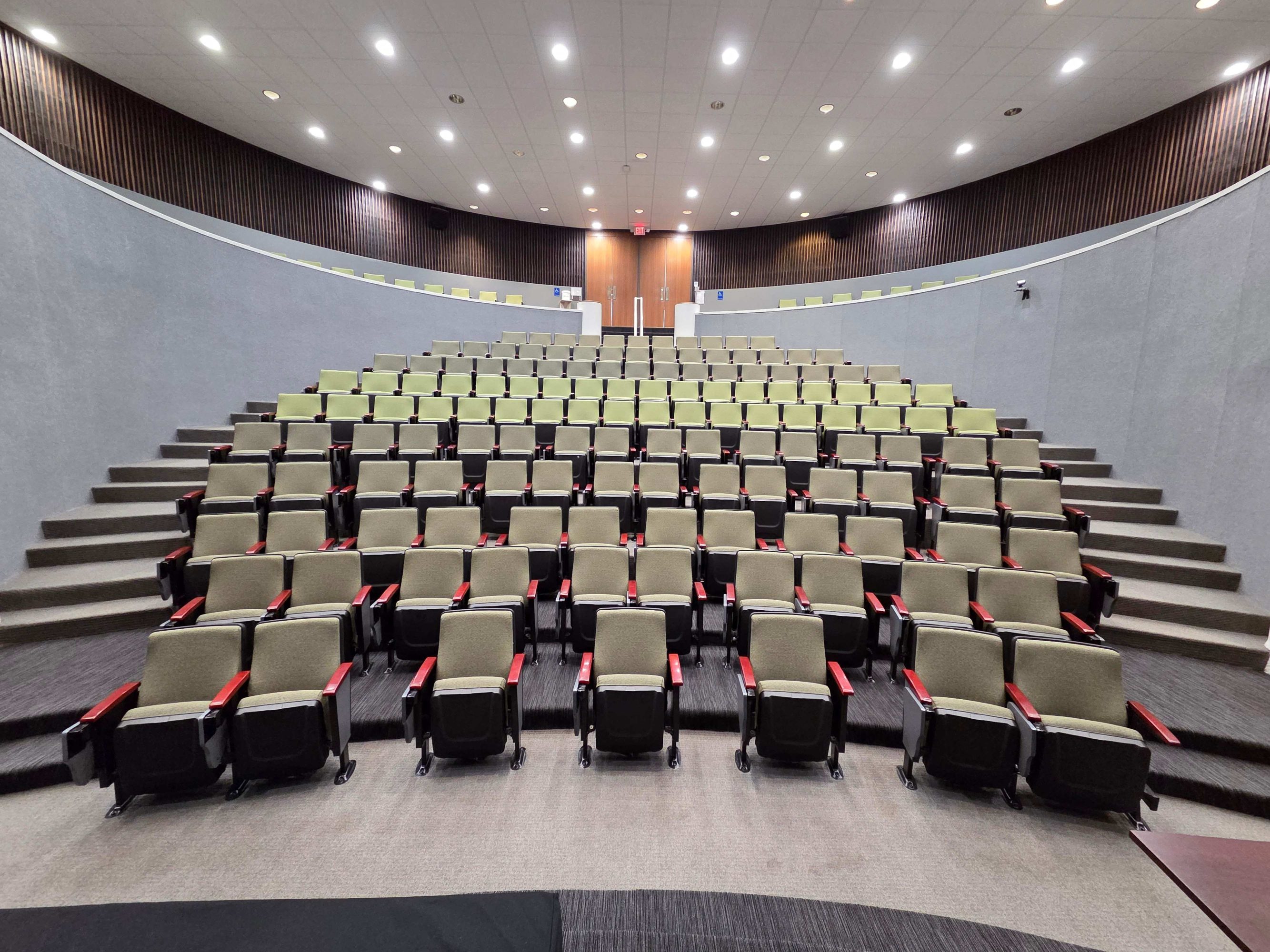 An image of a room of tiered empty green chairs