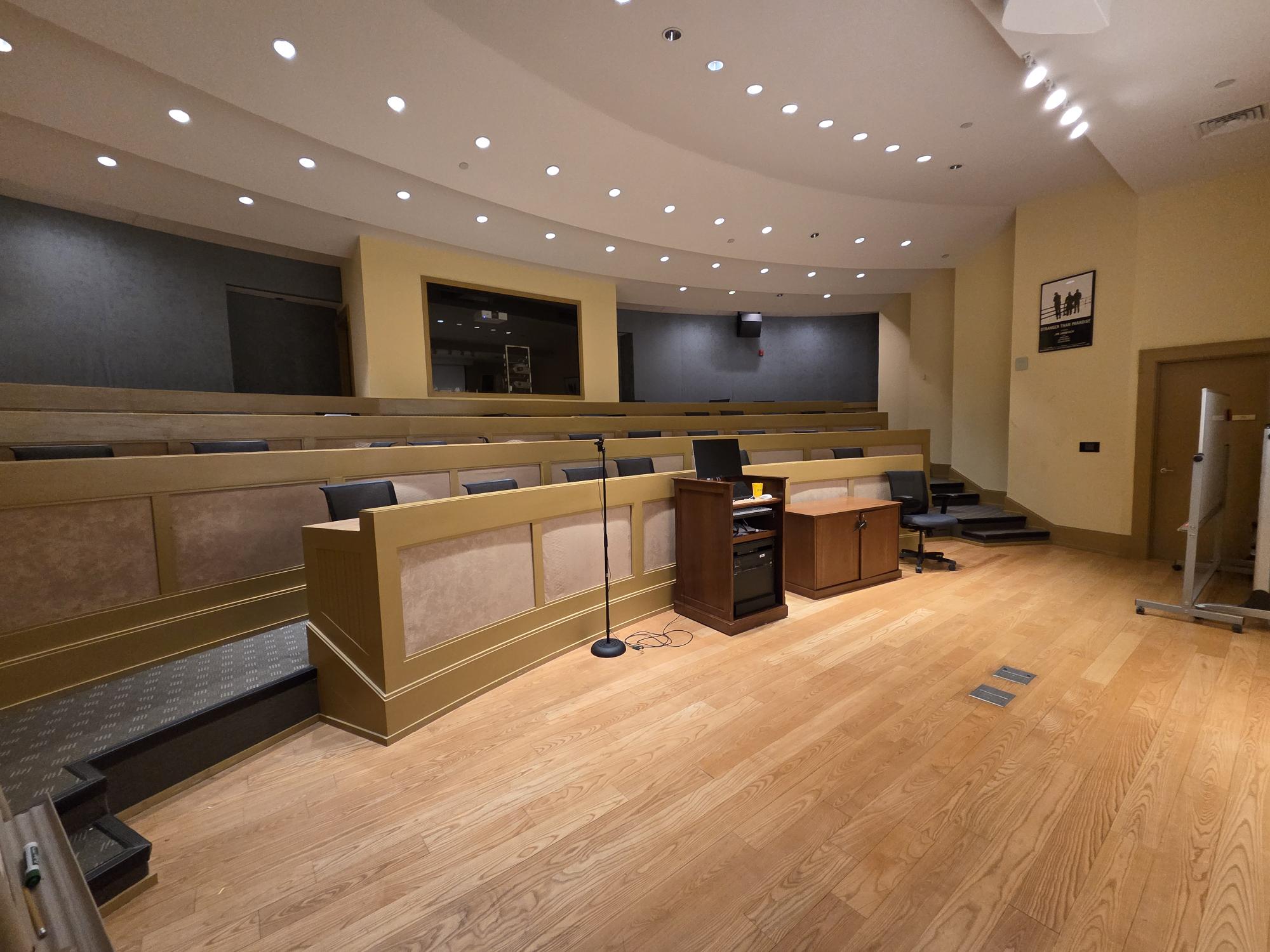 A small auditorium with chairs behind high tables.