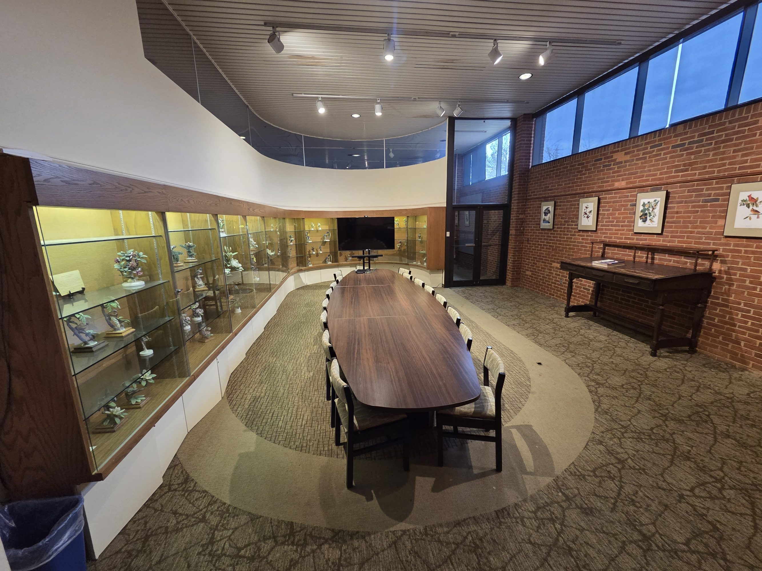 A small room with a conference table surrounded by empty chairs.